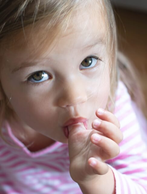 Toddler girl sucking her thumb