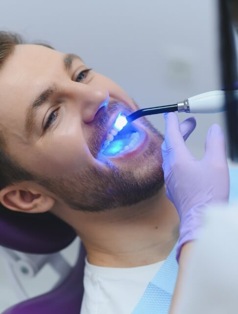 Man in dental chair receiving a dental exam