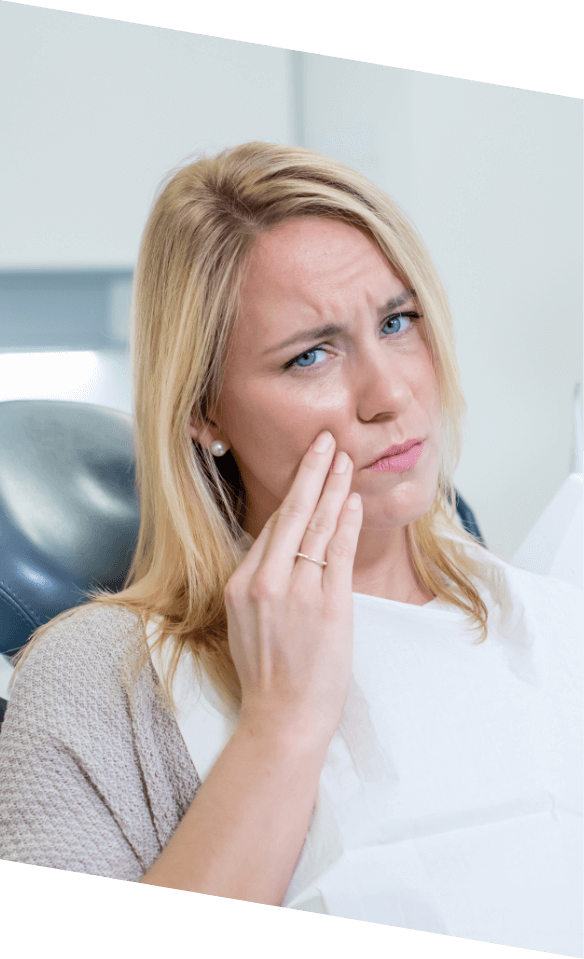 Woman touching her cheek in pain while visiting emergency dentist in Castle Rock