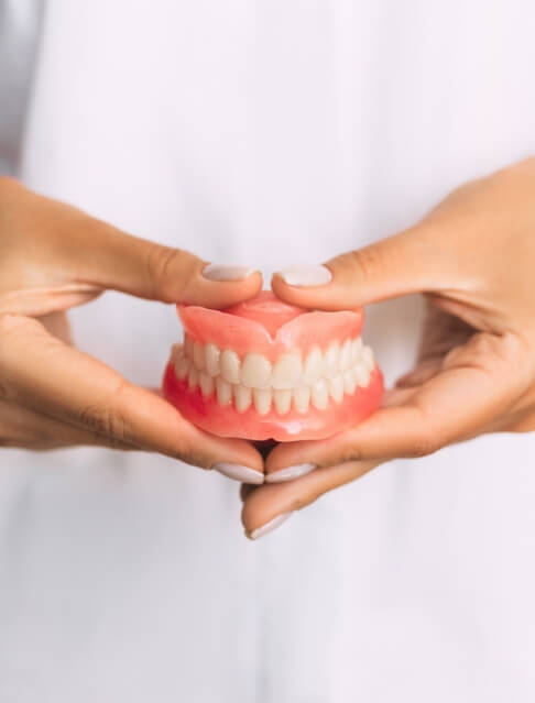 Dentist holding a set of full dentures