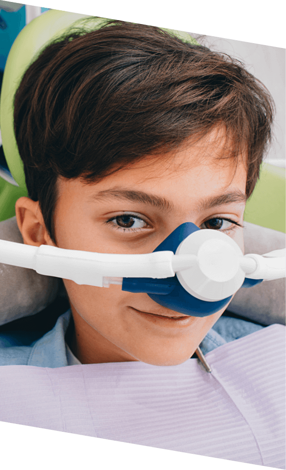 Young boy in dental chair wearing nitrous oxide sedation dentistry mask