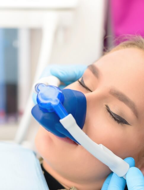 Woman with eyes closed wearing nose mask for nitrous oxide sedation dentistry