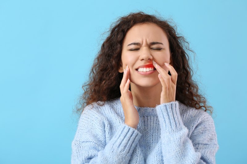 Woman touching her gums due to oral bumps